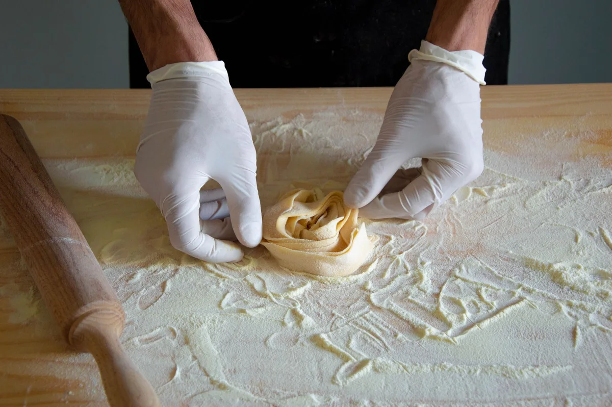 Mani al lavoro nella preparazione della pasta fresca